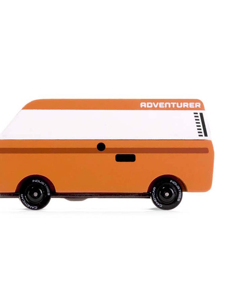 The VW-inspired brown toy van, known as the "ADVENTURER," by Candylab features a white roof, black wheels, and minimalistic design, offering timeless fun for young explorers.