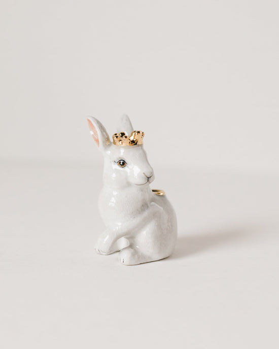 A Camp Hollow Royal White Rabbit Cake Topper, a white ceramic rabbit figurine with a small golden crown on its head, seated against a plain light background.