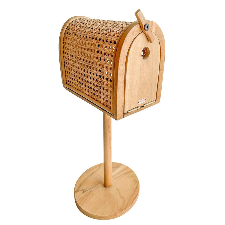 The Poppie Mailbox - Out of Stock ETA OCT by poppie toys is a delightful wooden mailbox featuring a woven rattan cover, gracefully perched on a circular wooden stand.